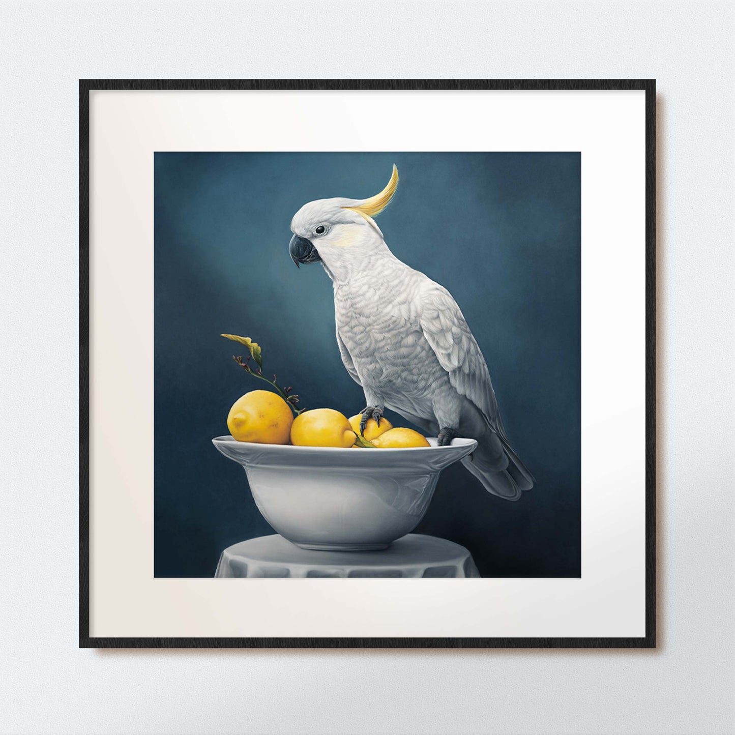 Framed artwork of a white cockatoo sitting on a bowl of lemons
